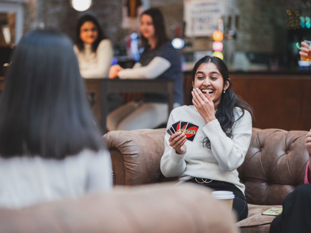 Image of some students sitting at a table and laughing